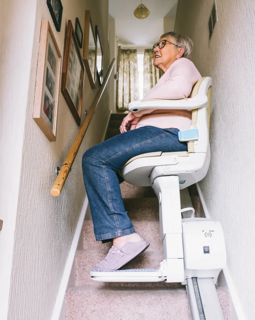 Senior using stairlift during free home assessment