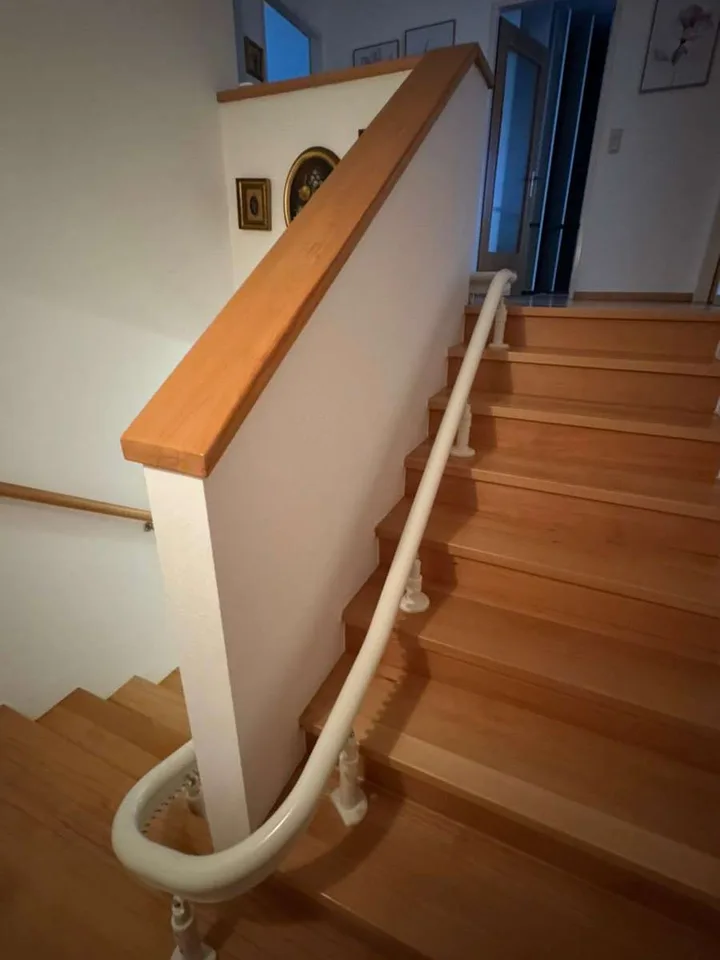 Curved stairlift installation in Montrose, TX — 1928 Montrose duplex — 180° switchback rail past an original newel post — photo 2