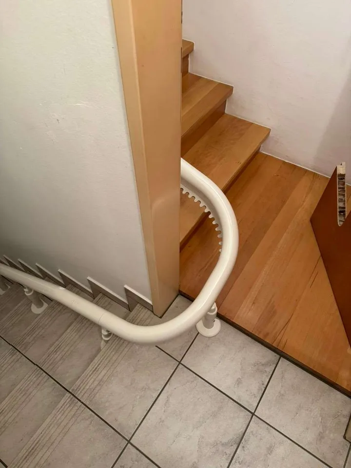 Curved stairlift installation in Montrose, TX — 1928 Montrose duplex — 180° switchback rail past an original newel post — photo 3