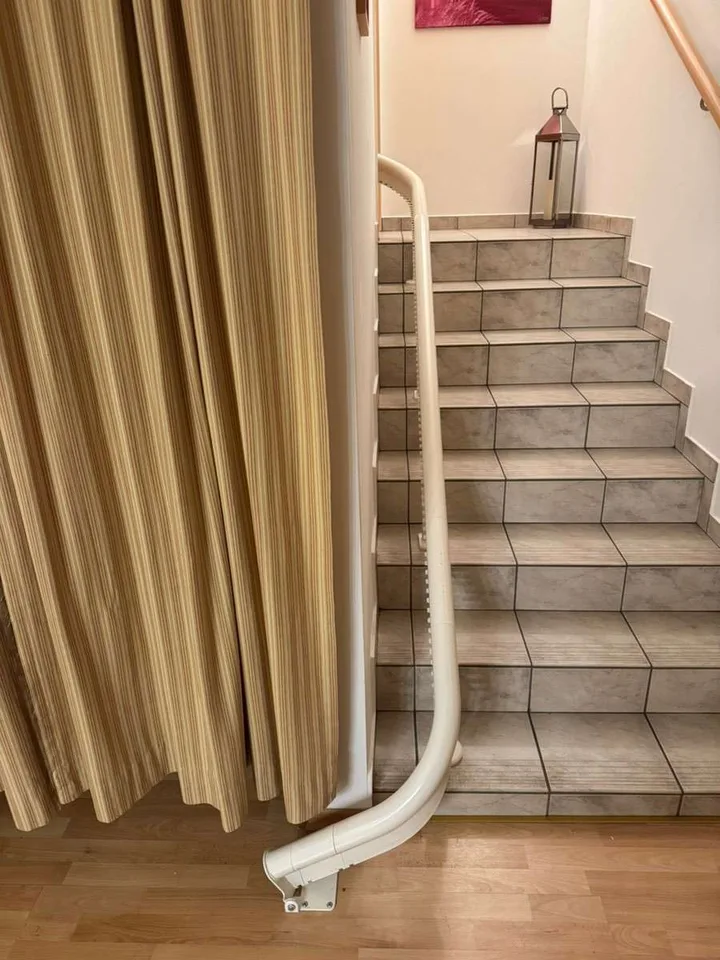 Curved stairlift installation in Montrose, TX — 1928 Montrose duplex — 180° switchback rail past an original newel post — photo 4